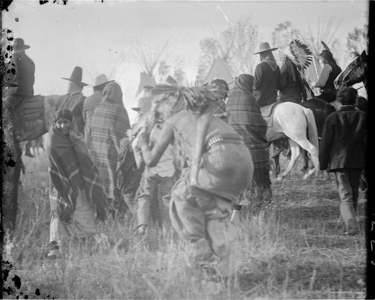A Crow clown teases a young child. Throughout the Sioux visit to Crow country there was a lot of dancing and merriment. / Fred Miller Collection, Smithsonian Institute