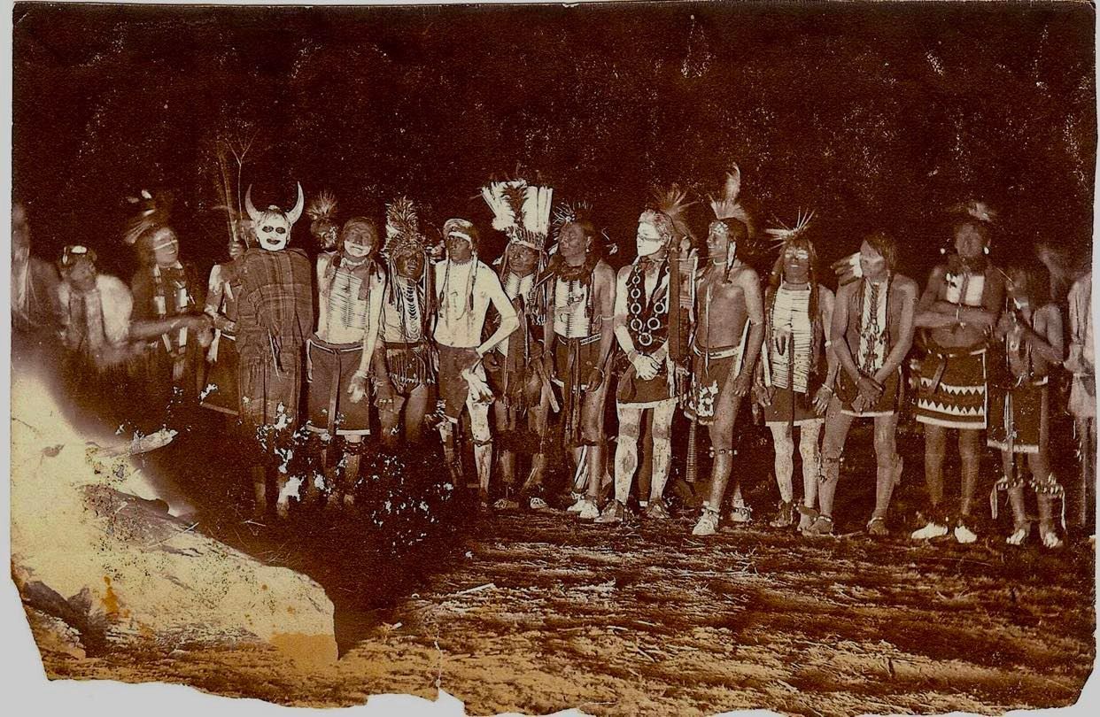 Sioux men dancing with a Crow clown with horns. This photo, is one of the earliest examples of flash photography in the world. / Historic photo from the Fred Miller Collection at the Smithsonian National Museum of the American Indian