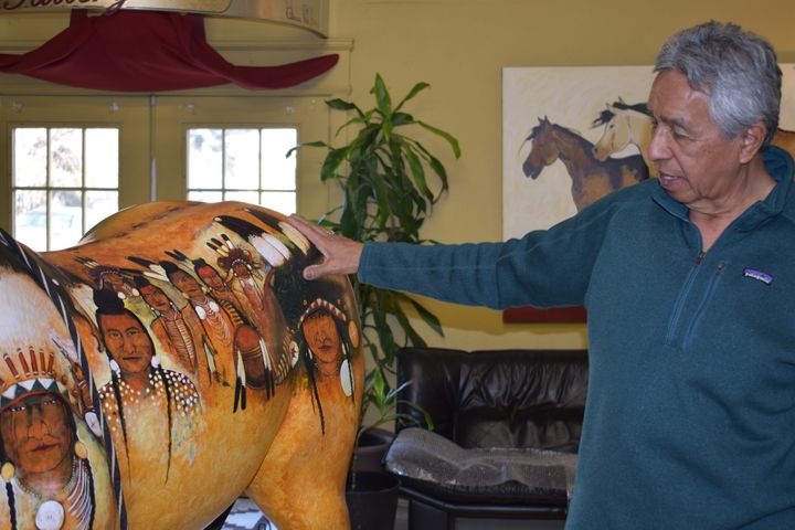 Distinctive Redstar depictions of Apsáalooke faces adorn a fiberglass horse, part of a larger art project that included multi